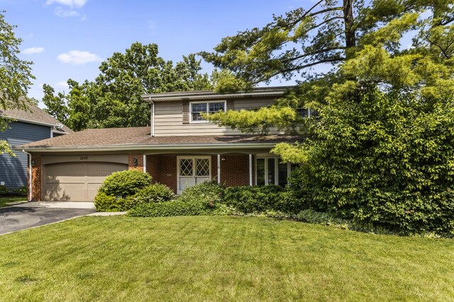 1145 Wincanton Dr, Deerfield, IL 60015 - traditional-style house featuring asphalt driveway, brick siding, a front yard, and an attached garage