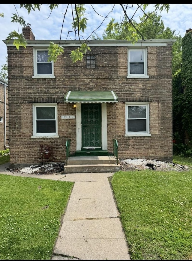 9151 S Perry Ave, Chicago, IL 60620 - view of front of house featuring a front lawn, a chimney, and brick siding