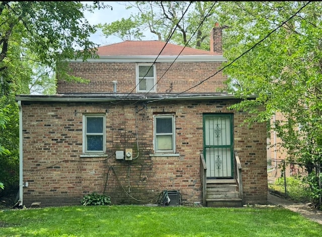 9151 S Perry Ave, Chicago, IL 60620 - rear view of house with entry steps, a chimney, and brick siding
