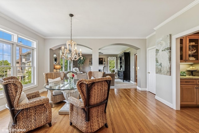 9520 Nicklaus Ln, Crystal Lake, IL 60014 - dining room featuring arched walkways, a chandelier, light wood-style floors, and crown molding