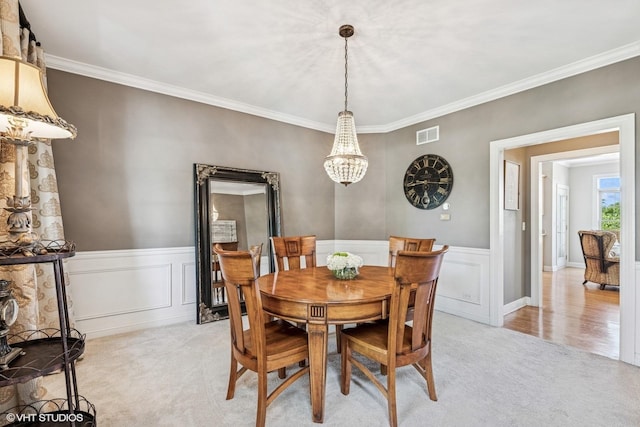 9520 Nicklaus Ln, Crystal Lake, IL 60014 - dining space featuring light colored carpet, ornamental molding, a chandelier, and a wainscoted wall