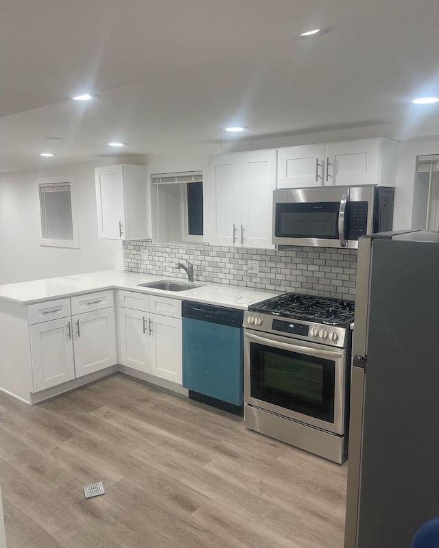 6141 S Eberhart Ave, Chicago, IL 60637 - kitchen featuring stainless steel appliances, a sink, white cabinetry, a peninsula, and backsplash