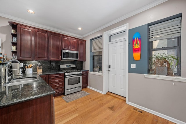 3405 N Harding Ave Unit 1, Chicago, IL 60618 - kitchen with appliances with stainless steel finishes, a sink, baseboards, backsplash, and light wood-style floors