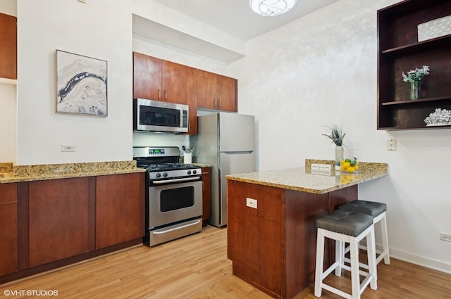 4537 S Drexel Blvd Unit 106, Chicago, IL 60653 - kitchen with appliances with stainless steel finishes, a peninsula, light wood-style floors, and a breakfast bar