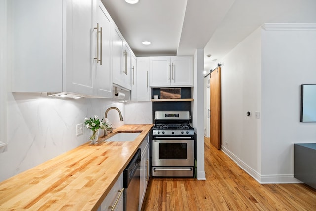 1443 N Mohawk St Unit 1, Chicago, IL 60610 - kitchen with stainless steel appliances, wood counters, light wood-style flooring, white cabinets, and tasteful backsplash
