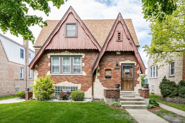 3730 Wenonah Ave, Berwyn, IL 60402 - tudor house featuring a front yard, roof with shingles, and brick siding