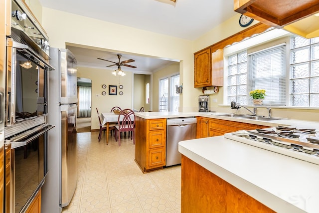 3730 Wenonah Ave, Berwyn, IL 60402 - kitchen with appliances with stainless steel finishes, brown cabinetry, a peninsula, ceiling fan, and crown molding