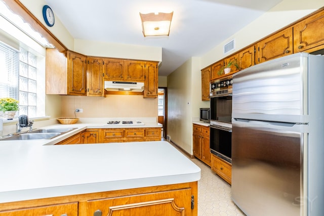 3730 Wenonah Ave, Berwyn, IL 60402 - kitchen featuring freestanding refrigerator, a sink, under cabinet range hood, white gas cooktop, and light countertops