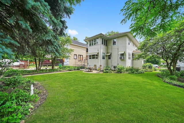 3218 Wenonah Ave, Berwyn, IL 60402 - back of property with a yard, stucco siding, a patio, and cooling unit