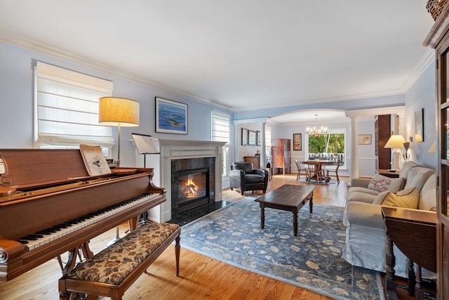 948A Shetland Dr, Frankfort, IL 60423 - living area featuring ornate columns, a chandelier, wood finished floors, crown molding, and a fireplace with flush hearth