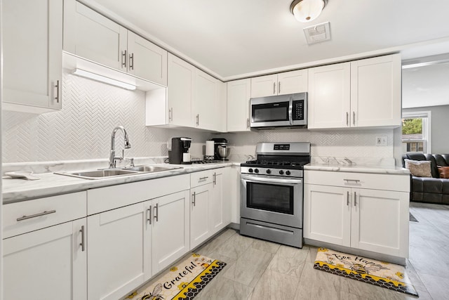 417 Dellwood Ave, Lockport, IL 60441 - kitchen with stainless steel appliances, white cabinets, tasteful backsplash, and light stone counters