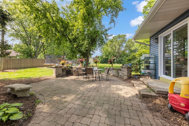 1907 S St, Geneva, IL 60134 - fenced backyard featuring a trampoline, a patio, and outdoor dining area