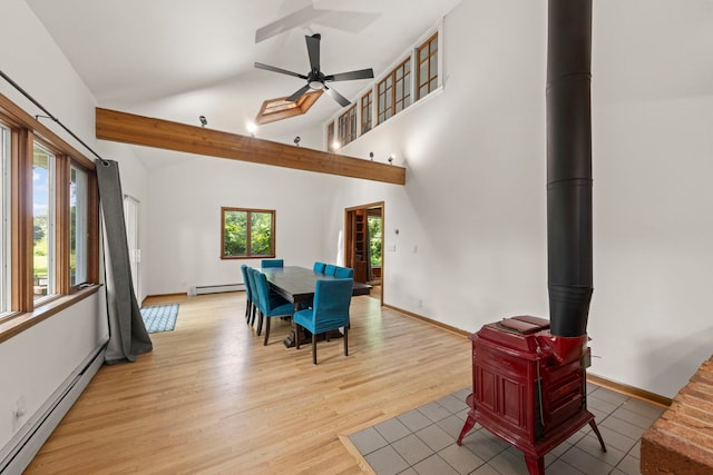 1907 S St, Geneva, IL 60134 - dining space with a baseboard radiator, a wood stove, a ceiling fan, light wood-type flooring, and high vaulted ceiling