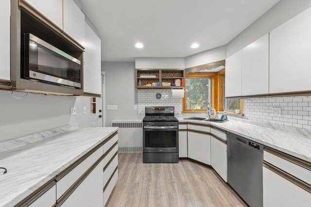 1907 S St, Geneva, IL 60134 - kitchen featuring appliances with stainless steel finishes, light wood finished floors, radiator heating unit, light countertops, and white cabinetry
