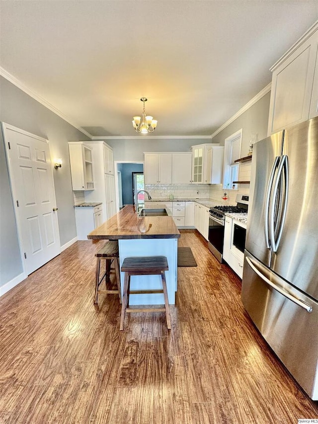732 S 13th, Quincy, IL 62301 - kitchen featuring freestanding refrigerator, range with gas cooktop, a chandelier, white cabinetry, and dark wood-style floors