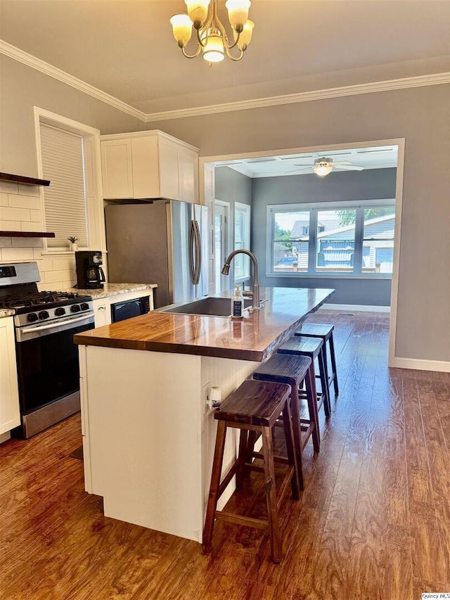 732 S 13th, Quincy, IL 62301 - kitchen with appliances with stainless steel finishes, butcher block countertops, a chandelier, white cabinetry, and dark wood-type flooring