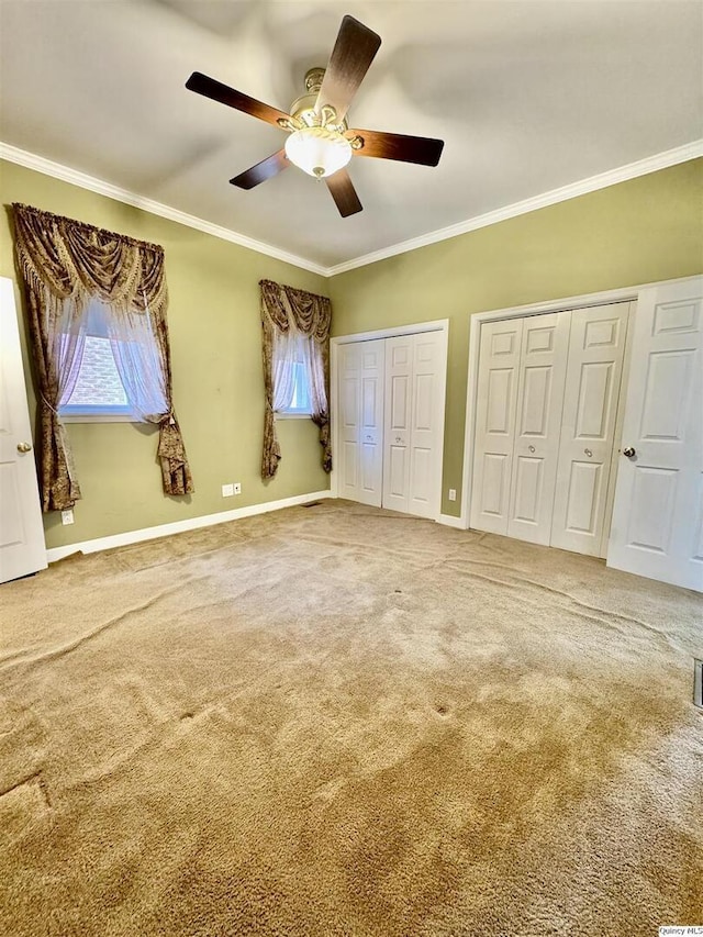 732 S 13th, Quincy, IL 62301 - unfurnished bedroom featuring two closets, crown molding, carpet flooring, baseboards, and ceiling fan