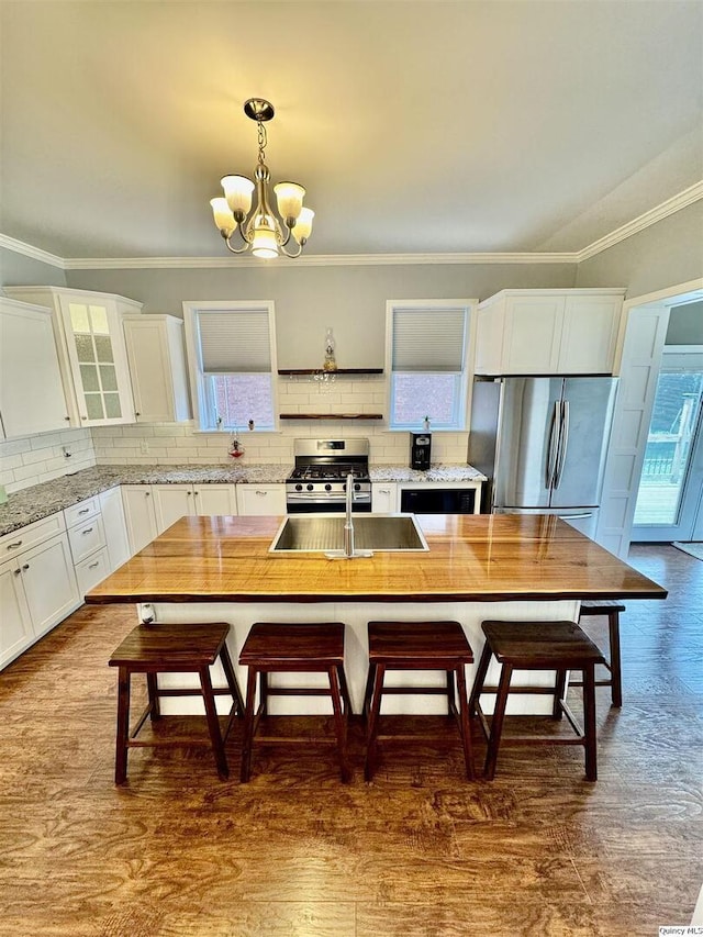 732 S 13th, Quincy, IL 62301 - kitchen featuring appliances with stainless steel finishes, tasteful backsplash, white cabinets, a chandelier, and a sink