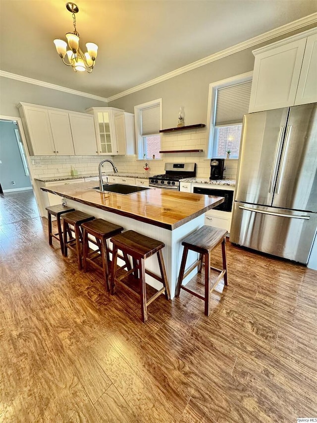 732 S 13th, Quincy, IL 62301 - kitchen with stainless steel appliances, wooden counters, a sink, a chandelier, and decorative backsplash