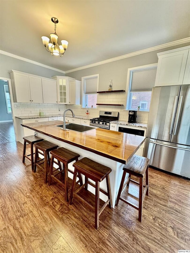 732 S 13th, Quincy, IL 62301 - kitchen featuring appliances with stainless steel finishes, a sink, a chandelier, a kitchen bar, and ornamental molding