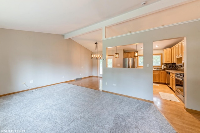 2510 Timber Ln, Lindenhurst, IL 60046 - unfurnished living room featuring a chandelier, light colored carpet, and light wood-type flooring