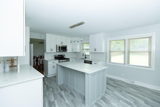 3145 Hillside Ln, Darien, IL 60561 - kitchen with appliances with stainless steel finishes, white cabinetry, a kitchen island, and pendant lighting