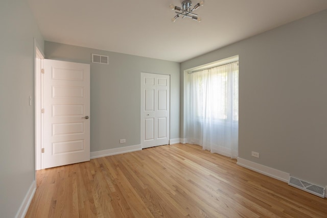 3145 Hillside Ln, Darien, IL 60561 - unfurnished bedroom featuring light wood-style flooring and a chandelier