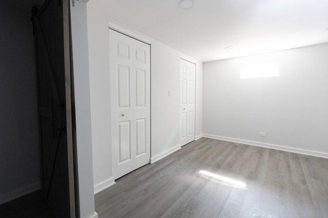 3145 Hillside Ln, Darien, IL 60561 - unfurnished bedroom with wood finished floors and a barn door