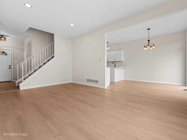 18506 Bellagio Cir, Tinley Park, IL 60477 - unfurnished living room with a chandelier, stairway, light wood finished floors, and recessed lighting