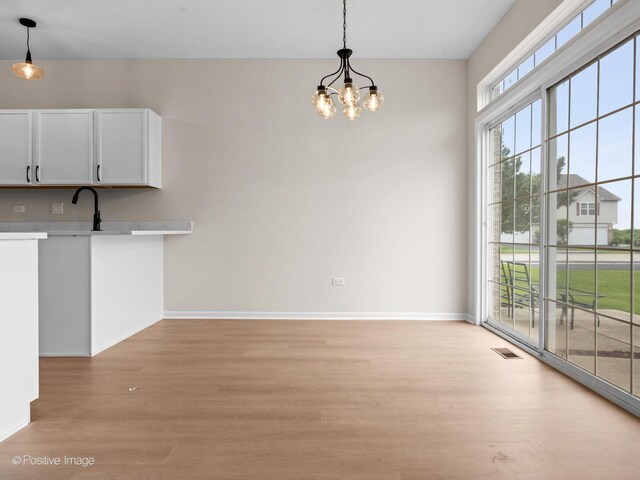 18506 Bellagio Cir, Tinley Park, IL 60477 - unfurnished dining area with light wood-style floors and a chandelier