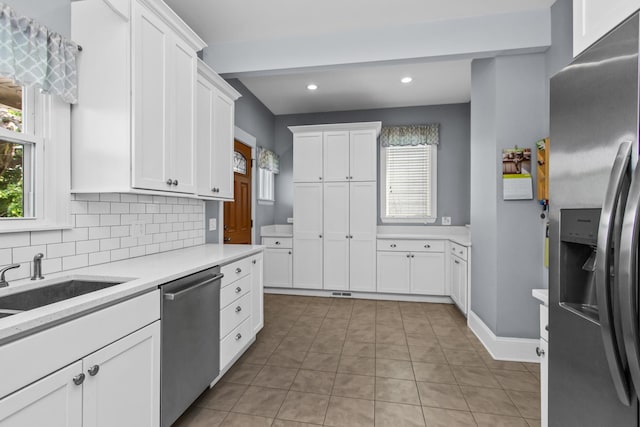 4039 N Kildare Ave, Chicago, IL 60641 - kitchen featuring appliances with stainless steel finishes, light countertops, healthy amount of natural light, white cabinetry, and recessed lighting