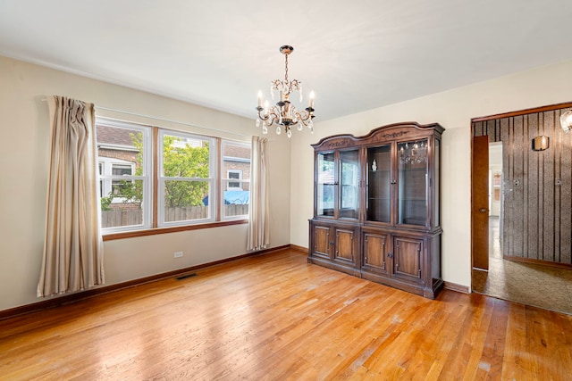 2728 N Neva Ave, Chicago, IL 60707 - spare room with a chandelier and light wood-type flooring