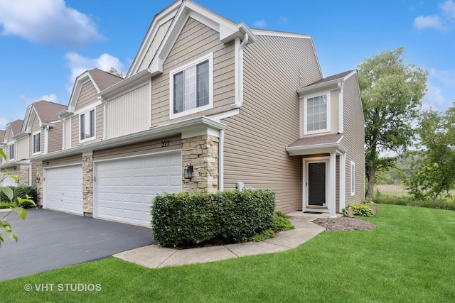 377 Locksley Dr, Streamwood, IL 60107 - townhome / multi-family property with a garage, a front lawn, stone siding, and asphalt driveway