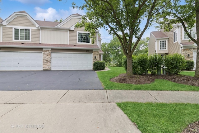 377 Locksley Dr, Streamwood, IL 60107 - townhome / multi-family property with asphalt driveway, stone siding, an attached garage, and a front lawn