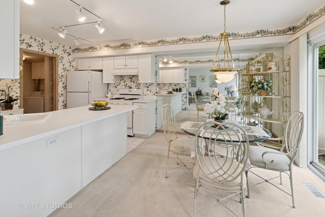377 Locksley Dr, Streamwood, IL 60107 - dining room featuring washer / dryer, wallpapered walls, track lighting, and light colored carpet