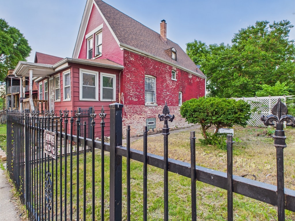 1233 S Karlov Ave, Chicago, IL 60623 - view of side of property featuring a chimney, brick siding, and a shingled roof