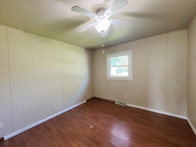 310 N 3rd Ave, Chenoa, IL 61726 - empty room with wood finished floors, ceiling fan, baseboards, and wooden walls