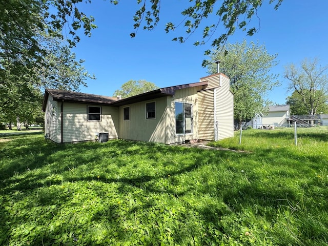 310 N 3rd Ave, Chenoa, IL 61726 - rear view of property featuring a lawn