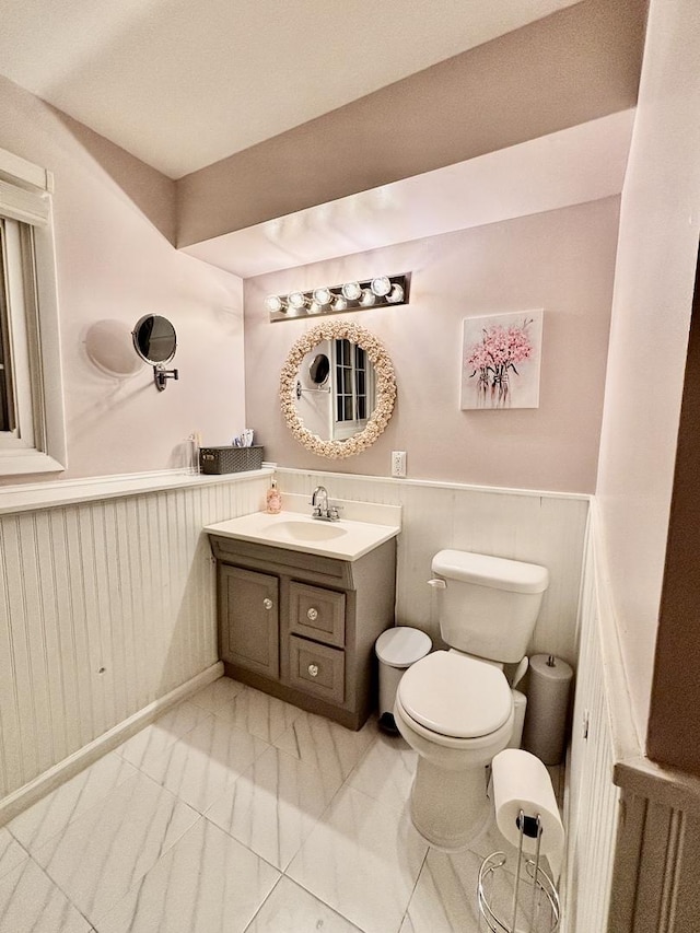 826 Dartmoor Dr, Crystal Lake, IL 60014 - half bath featuring toilet, wainscoting, vanity, and marble look tiles