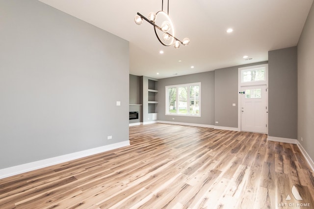 10921 S Hermosa Ave, Chicago, IL 60643 - unfurnished living room with light wood-type flooring, recessed lighting, a chandelier, baseboards, and built in shelves