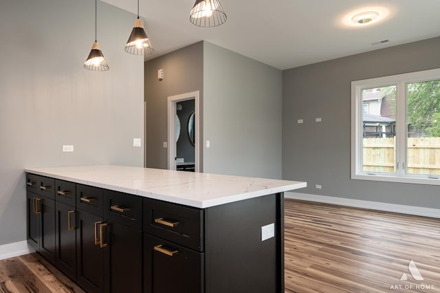 10921 S Hermosa Ave, Chicago, IL 60643 - kitchen with a peninsula, light wood-type flooring, baseboards, light stone counters, and dark cabinetry