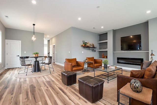 10921 S Hermosa Ave, Chicago, IL 60643 - living room featuring light wood finished floors, built in shelves, baseboards, a glass covered fireplace, and recessed lighting