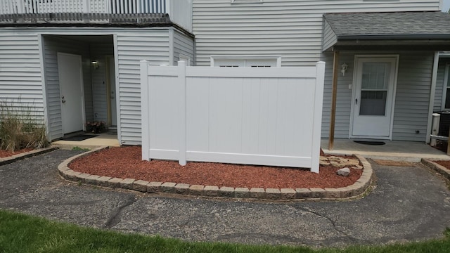 2330 Carnation Dr Unit 2330, Crest Hill, IL 60403 - view of exterior entry featuring a shingled roof and a balcony
