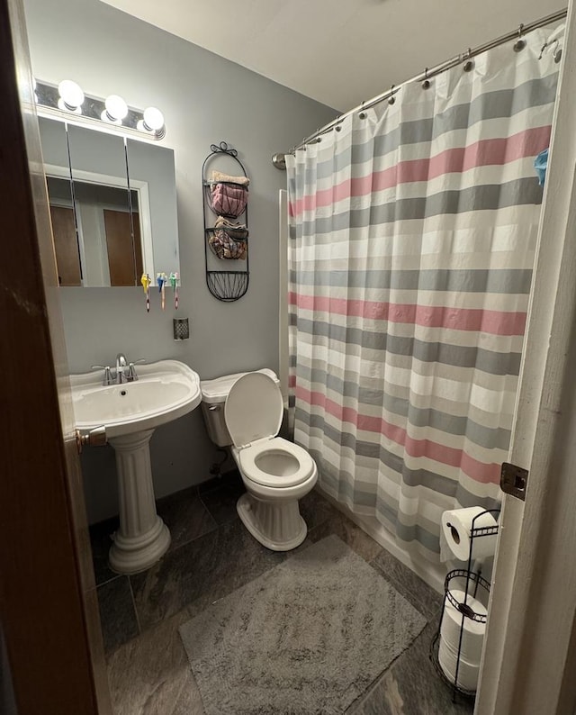 5280 S Harlan Dr, Rochelle, IL 61068 - bathroom with toilet, a shower with shower curtain, and stone finish floors