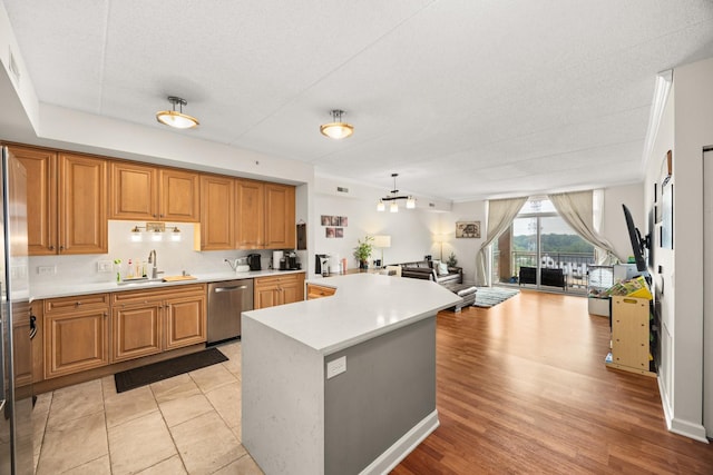 8340 Callie Ave Unit 506, Morton Grove, IL 60053 - kitchen with stainless steel dishwasher, a sink, open floor plan, light countertops, and a kitchen island