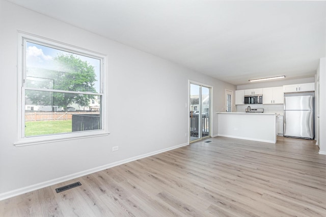 7490 Filmore Ave, Hanover Park, IL 60133 - unfurnished living room with light wood-style floors and plenty of natural light