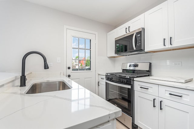 7490 Filmore Ave, Hanover Park, IL 60133 - kitchen with appliances with stainless steel finishes, white cabinets, tasteful backsplash, and light stone countertops
