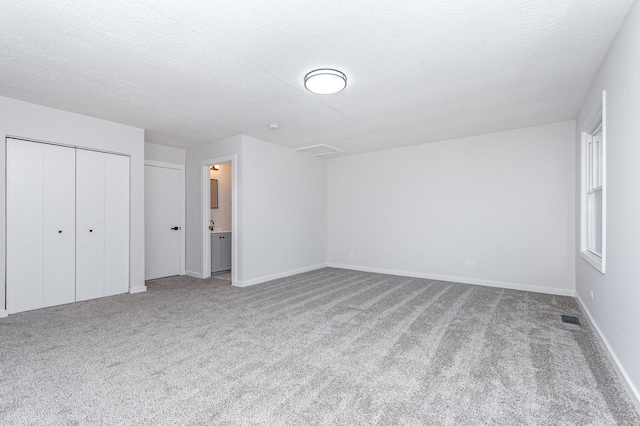7490 Filmore Ave, Hanover Park, IL 60133 - unfurnished bedroom featuring carpet floors, a textured ceiling, a closet, and connected bathroom