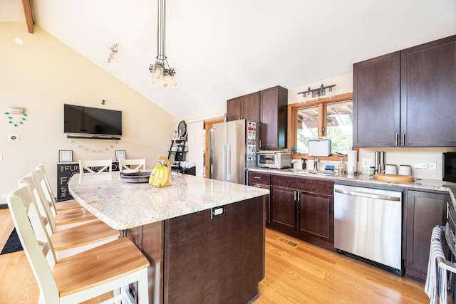 25429 W Cedar Crest Ln, Lake Villa, IL 60046 - kitchen featuring appliances with stainless steel finishes, light wood-style flooring, a kitchen island, a kitchen bar, and dark brown cabinets