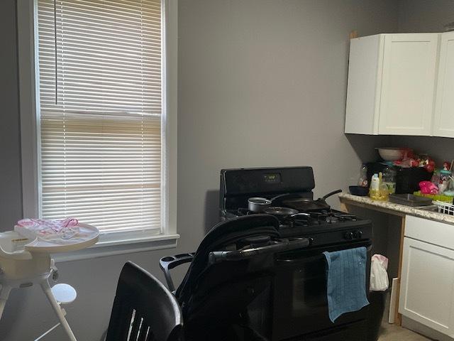 8205 S Houston Ave, Chicago, IL 60617 - kitchen with black gas range, white cabinetry, and light countertops